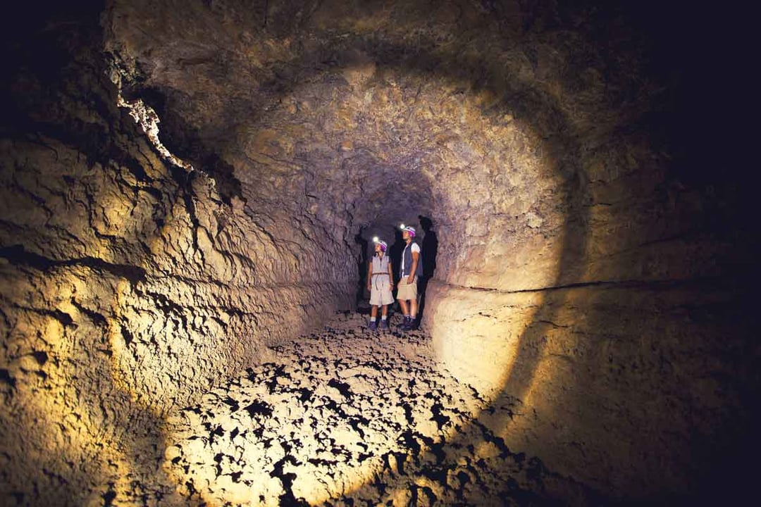 Two visitors inside the Wind Cave in Tenerife examine its geology