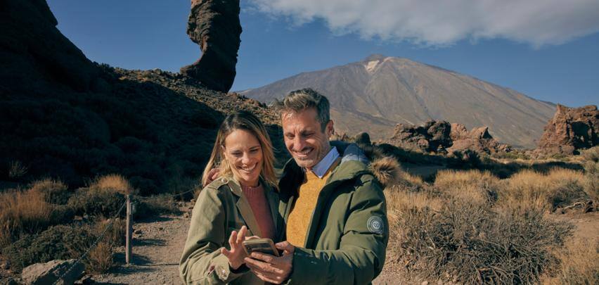 Pareja con la app Teide Legend que podrán hacer la ruta guiada al Mirador Pico Viejo cuando suban en Teleférico.